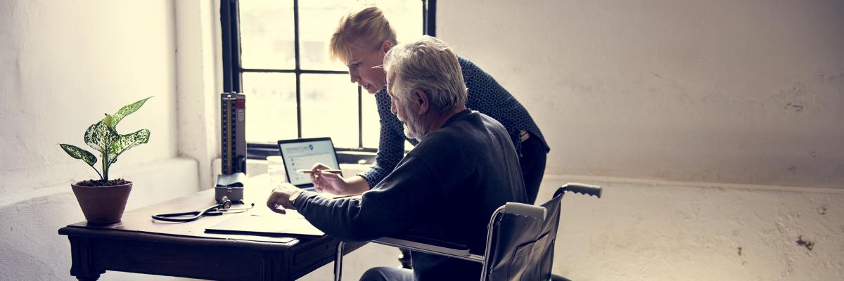 Man in wheelchair getting help picking life insurance